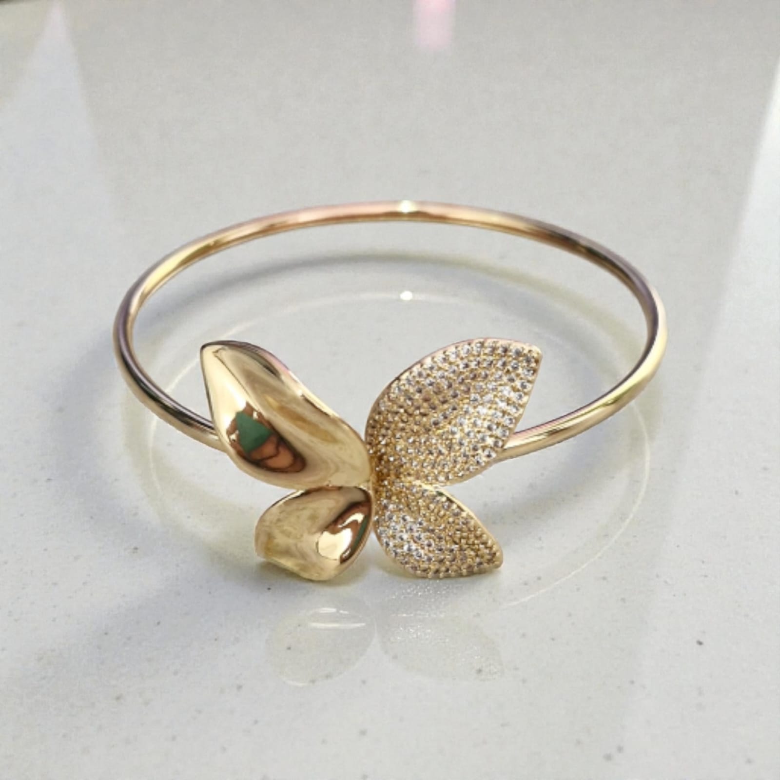 Bracelete Borboleta Cristal Violeta Rio — bracelete (rígido fino), cor dourado e transparente, metal dourado e micro-zircônias/strasses