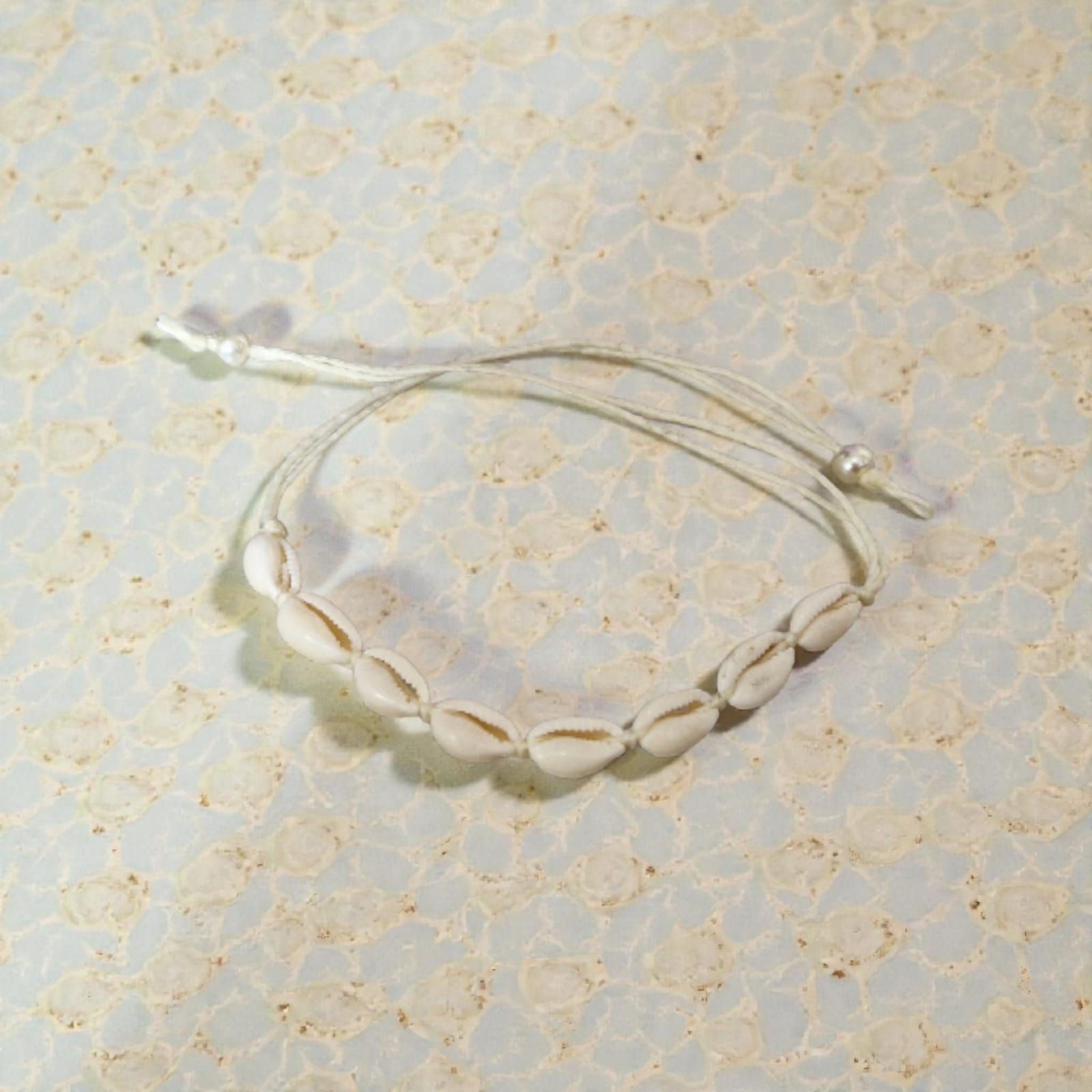 Pulseira Búzios Naturais Violeta Rio — pulseira (cordão ajustável), cor branco/off-white, conchas naturais (búzios), fio de algodão/linho, miçangas
